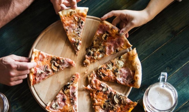 Bustling community with plenty of dining choices a group of people are eating pizza